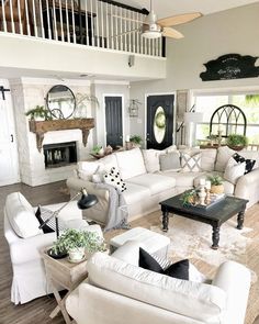 a living room filled with white furniture and lots of windows