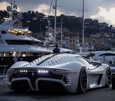 the futuristic car is parked in front of some boats