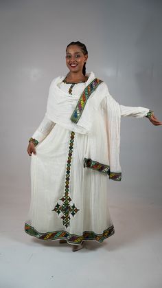 Simple Ethiopian dress with a beautiful trim and hand embroidery. This dress comes with full netela (two panel 2m scarf). Model is wearing a A/M but It can be custome made in any size. please and your measurement when you place your order and also your phone number. phone numebr is required on the shipping form. Fitted Anarkali Dress With Traditional Embroidery, Ceremonial Dresses With Embroidered Border And Traditional Drape, White Dresses With Embroidered Border And Traditional Drape, Traditional Ceremony Dress With Embroidered Border, Wedding Dress With Embroidered Border And Traditional Drape, Fitted Dresses With Traditional Patterns And Drape, Traditional Fitted Dresses For Ceremonies, Floor-length Anarkali Dress With Embroidered Border, Anarkali Dress With Embroidered Border For Traditional Ceremonies