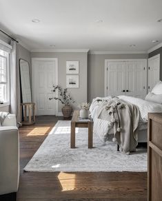 a bedroom with white furniture and gray walls