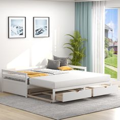 a white bed sitting in a bedroom on top of a hard wood floor next to a window