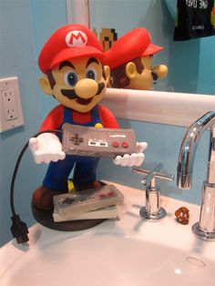 a nintendo wii game controller sitting on top of a sink next to a faucet