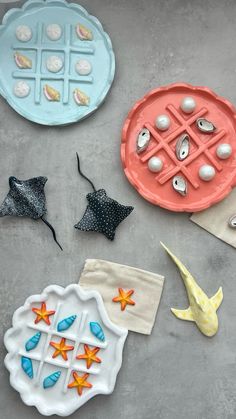 three clay plates with seashells and starfish on them, one has a fish