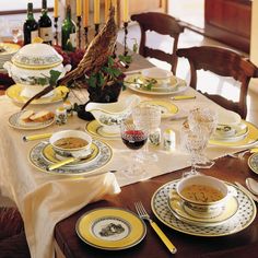 the table is set with yellow and white dishes