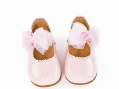 Elegant pair of baby and toddler Mary Janes, constructed with a baby pink patent leather upper, featuring pinking on a scalloped rim and strap. This pretty pair is adorned with an adorable pink bow. These shoes are lightly padded, crafted with soft leather lining, a breathable insole, and a rubber sole. These shoes are very comfortable and suitable for first walkers. Your little princess will look elegant and sophisticated in this beautiful pair of shoes. Product Details: versatile, durable, sup Pink Mary Janes For Spring Party, Cute Mary Janes For Spring Party, Cute Spring Mary Janes For Party, Cute Spring Party Mary Janes, Pink Closed Toe Mary Janes For Spring, Spring Pink Closed Toe Mary Janes, Pink Round Toe Mary Janes For Spring, Cute Pink Mary Janes For Spring, Tule Bows