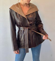 "Sourced from a high end leather & fur shop in Turkey, this hooded jacket is truly unique. Extremely soft dark brown leather with satin printed lining. This beautiful piece features two side pockets, detail stitching, slim shoulder pads, button down front and a waist tie belt. Oversize hooded collar with plaid fabric. Condition is excellent with no flaws to mention. Label: Emelda  Size: women's US 10 or Turkey size 40 Fit: best fits size Small-Medium  *Model is 5'7\" size small or US 2 for reference.  Shoulder to shoulder: 17\" Shoulder to hem: 27\" Sleeve length: 25.5\" Armpit to armpit: 20\"" Fitted Leather Outerwear With Double-lined Hood, Fitted Leather Hooded Jacket For Fall, Fitted Brown Leather Jacket With Padded Collar, Fall Hooded Leather Jacket With Padded Collar, Leather Jacket With Detachable Hood For Fall, Fitted Leather Hooded Jacket With Double-lined Hood, Fall Leather Jacket With Detachable Hood, Leather Jacket With Double-lined Hood, Fitted Hooded Leather Jacket With Padded Collar