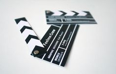 some black and white business cards on top of each other with the movie clapper attached to them