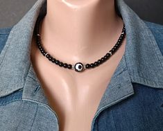 Unisex choker necklace in black onyx with eye agate center bead. Agate 3 Eye DZi. Fashion style men. Suitable as a gift boyfriend, gift for father.  Choker - black onyx (6 mm) and eye agate 3 eyes DZi (12 mm). details silver colored alloy. Length choker +/- 17 - 19 inches (43 - 48 cm). Recommendations for care: Do not wet, do not drop, store in a dark box.  wear with pleasure. Casual Black Beaded Choker Necklace, Black Evil Eye Round Beads Jewelry, Adjustable Onyx Choker Necklace, Black Spiritual Choker Necklace, Black Spiritual Jewelry With Evil Eye, Black Spiritual Necklace With Evil Eye Detail, Black Evil Eye Spiritual Necklace, Black Spiritual Necklace With Evil Eye, Spiritual Black Evil Eye Necklace