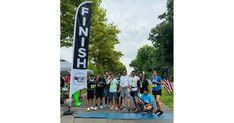 a group of people standing next to each other near a finish line