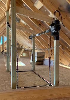 an unfinished attic with wooden beams and metal bars on the ceiling is being worked on