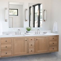 a bathroom with two sinks and mirrors in it