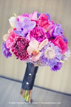 purple and pink flowers in a black vase