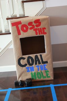 a cardboard box that says toss the coal in the hole