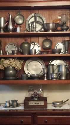 a wooden shelf filled with lots of silverware