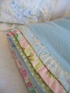 four different colored pillows stacked on top of each other in the same bedding set