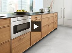 a modern kitchen with wooden cabinets and stainless steel appliance on the counter top