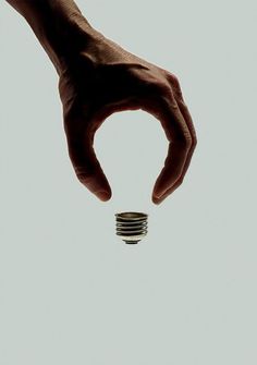 a hand holding a stack of coins in front of a white background with the caption that reads,