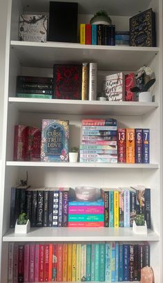 a white book shelf filled with lots of books