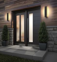 the front door of a house with two potted plants and lights on each side