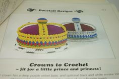 two crocheted crowns sitting on top of each other in front of a paper