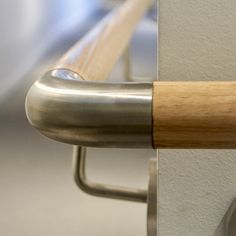 a close up of a metal handle on a door with a wooden bar attached to it