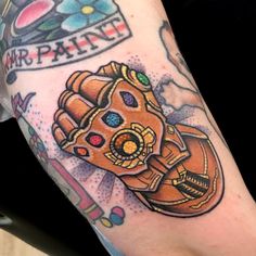 a close up of a person's arm with a tattoo on it and a cartoon character holding a baseball glove