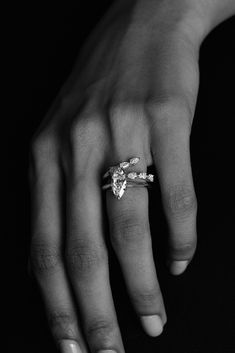 a woman's hand with a diamond ring on top of her left hand, black and white photo