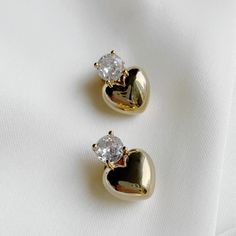 Elevate any outfit with The Scarlette Studs, featuring a puffed heart design adorned with a sparkling touch of cubic zirconia. Perfect for adding a touch of elegance and charm to any look. 18k Gold-Plated Brass Cubic Zirconia Post back closure Drop 15mm Jewelry Care: Clean metal jewelry with a soft cloth and mild soapy water. Avoid abrasive cleaners, steamers, or ultrasonic machines. Dry thoroughly and store dry place. Clean Metal, How To Clean Metal, Puffed Heart, Cuff Rings, Ring Sale, Earring Sale, Huggie Hoop Earrings, Soapy Water, Lariat Necklace