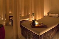 a massage room with candles and towels on the bed