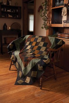 a quilted blanket sitting on top of a wooden chair