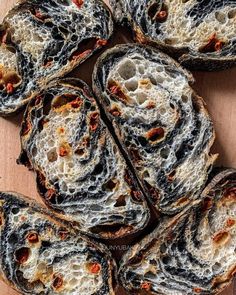 several pieces of bread that have been sliced into small pieces and are sitting on a wooden surface