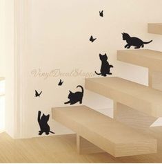 the cat wall stickers are on the stairs in this room, and it looks like they're falling off