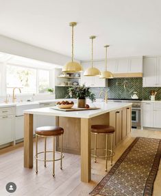 a kitchen island with two stools in front of it and an area rug on the floor