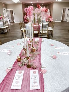 the table is set with pink and white decorations