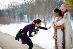 a man and woman are taking pictures in the snow with their cameraman's arm around them