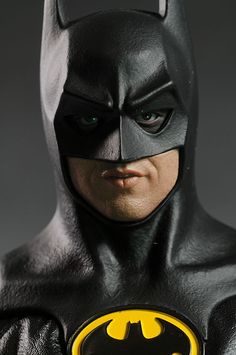 the batman action figure is shown in black leather and has a yellow logo on its chest