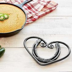 a heart shaped cookie next to a cast iron skillet with a green pepper on it