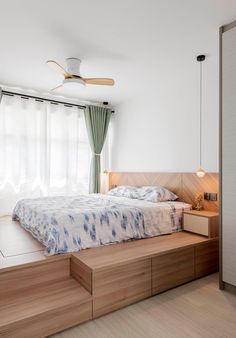 a bedroom with a bed, dresser and ceiling fan