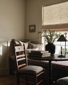 a living room filled with furniture and a window covered in blinds next to a table