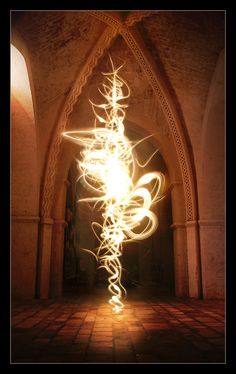 a light painting in the middle of a room with an archway and brick flooring