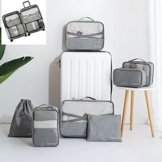 four pieces of luggage sitting on the floor next to a plant and potted plant