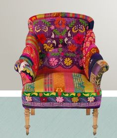 a colorfully decorated chair sitting on top of a blue floor