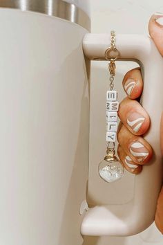 a woman is holding onto the handle of a urinal with her name on it