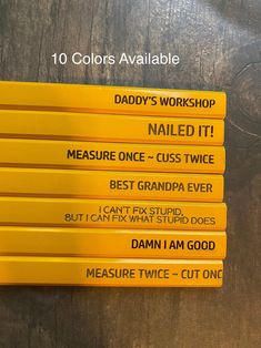 five yellow pencils sitting on top of a wooden table with the words daddy's workshop