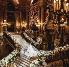 the bride is walking down the stairs in her wedding dress and bouquets on the steps