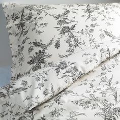 a white and black floral print comforter set with two pillow cases, one is made from