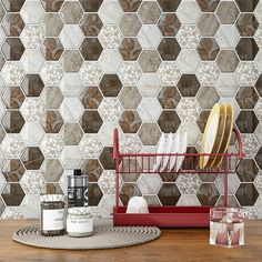 a wooden table topped with dishes and utensils next to a wallpaper pattern