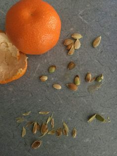 an orange and some seeds on a table