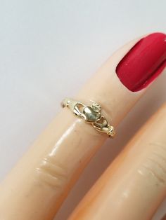 "Thanks for shopping our vintage estate store. We tend to sell well below wholesale and truly hope you enjoy all of our items. Many of the items are one of a kind, so please enjoy scrolling through the pictures and hopefully something will catch your eye. Blacks spots are from camera or reflections. Beautiful estate 14k gold yellow gold Irish Claddagh infant or baby ring. Retails $199 on sale $79 Ring size: 1 Setting: 1/4\" 4.5mm Band width: 1mm Weight: .65 gram Beautiful ring, one that someone Irish Claddagh, Baby Rings, Heart Hands, Black Spot, Beautiful Rings, Ring Size, Yellow Gold, Yellow, Band