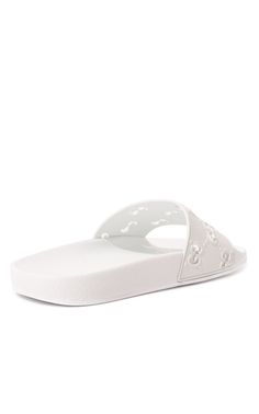 On these white rubber slippers, the diamond-shaped pattern in the form of GG monograms, plays not only a decorative, but also a functional role. An openwork motif, made in the technique of perforations, conducts heat well from the legs. This comfort is also supported by an orthopedic insole that reduces the load on the joints.Composition: Rubber 100%Lining: Rubber 100%Sole: Rubber 100%Made in Italy Luxury White Classic Slides, Modern White Flat Slides, White Slippers With Textured Sole And Round Toe, Modern White Slides With Textured Footbed, Modern White Round Toe Slides, Classic White Slip-on Sandals, Designer White Sandals With Rubber Sole, Classic White Slides With Round Toe, White Flat Slippers With Textured Footbed